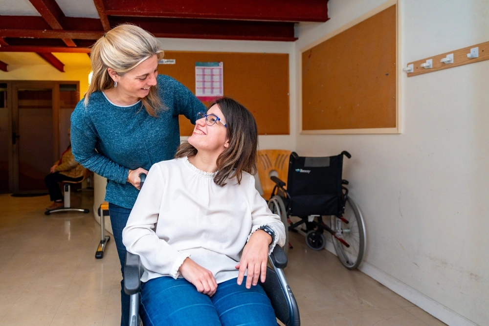 disabled girl on wheelchair with a disability support carer